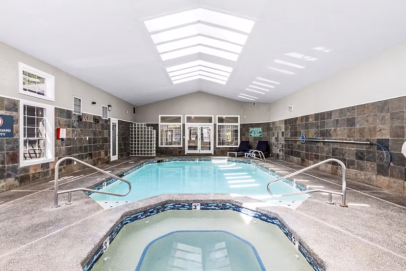 Rooftop pool with sun loungers at Avana West Hill Apartments, luxury living in a serene setting