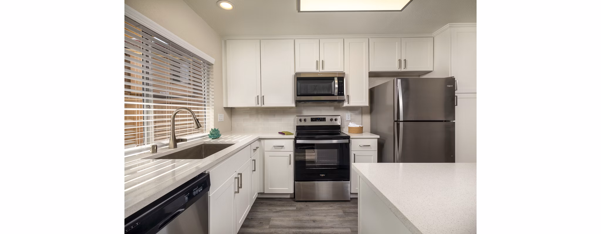 Modern kitchen with stainless steel appliances and marble countertops in Stone Arbor Apartments for luxury living
