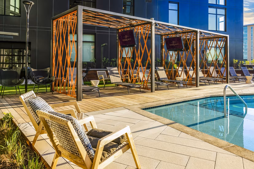 Relaxing pool patio with lounge seating at Harlowe Apartments, a Greystar luxury property