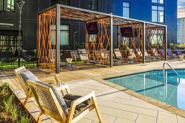 Relaxing pool patio with lounge seating at Harlowe Apartments, a Greystar luxury property