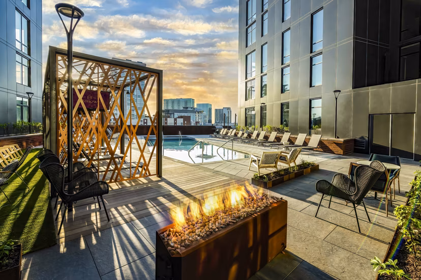 Relaxing outdoor area with pool and fire pit at Harlowe Apartments