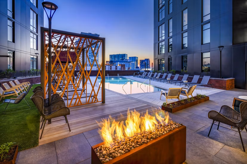 Cozy fire pit and sparkling pool at Harlowe Apartments, perfect for relaxation and gatherings in a luxury setting
