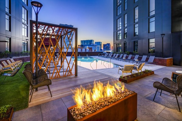 Cozy fire pit and sparkling pool at Harlowe Apartments, perfect for relaxation and gatherings in a luxury setting