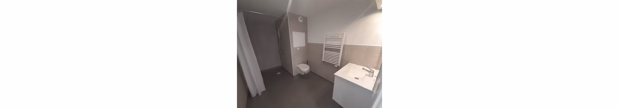 Compact and functional bathroom featuring a white sink, mirror, and towel warmer against a minimalistic design.