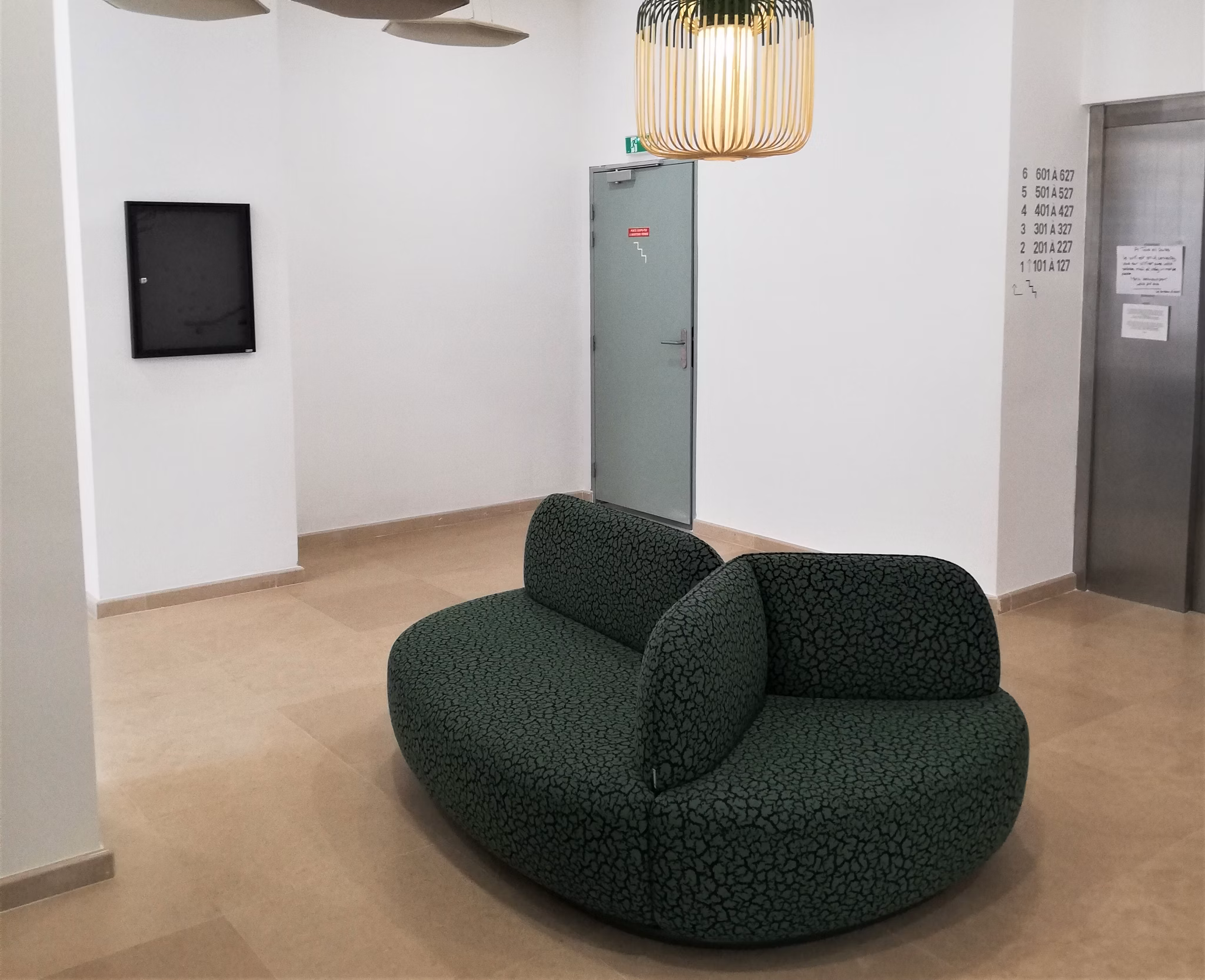 Chic lounge area with green upholstered seating and decorative accents offering a modern and inviting space.