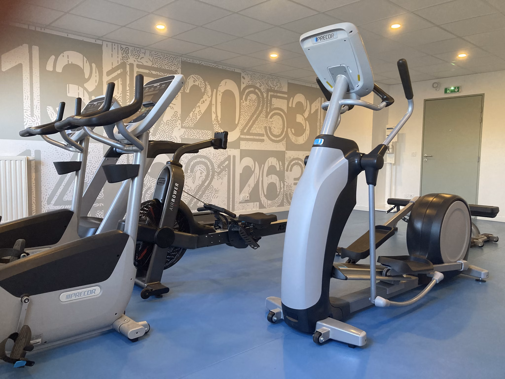 Spacious fitness center featuring cardio machines, free weights, and modern equipment with a motivational atmosphere.