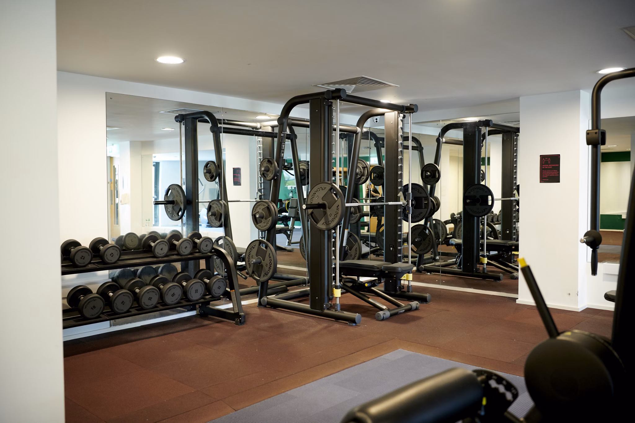 Fitness room at Canvas Glasgow equipped with weights and various exercise machines in a spacious setup.