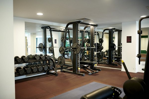 Fitness room at Canvas Glasgow equipped with weights and various exercise machines in a spacious setup.
