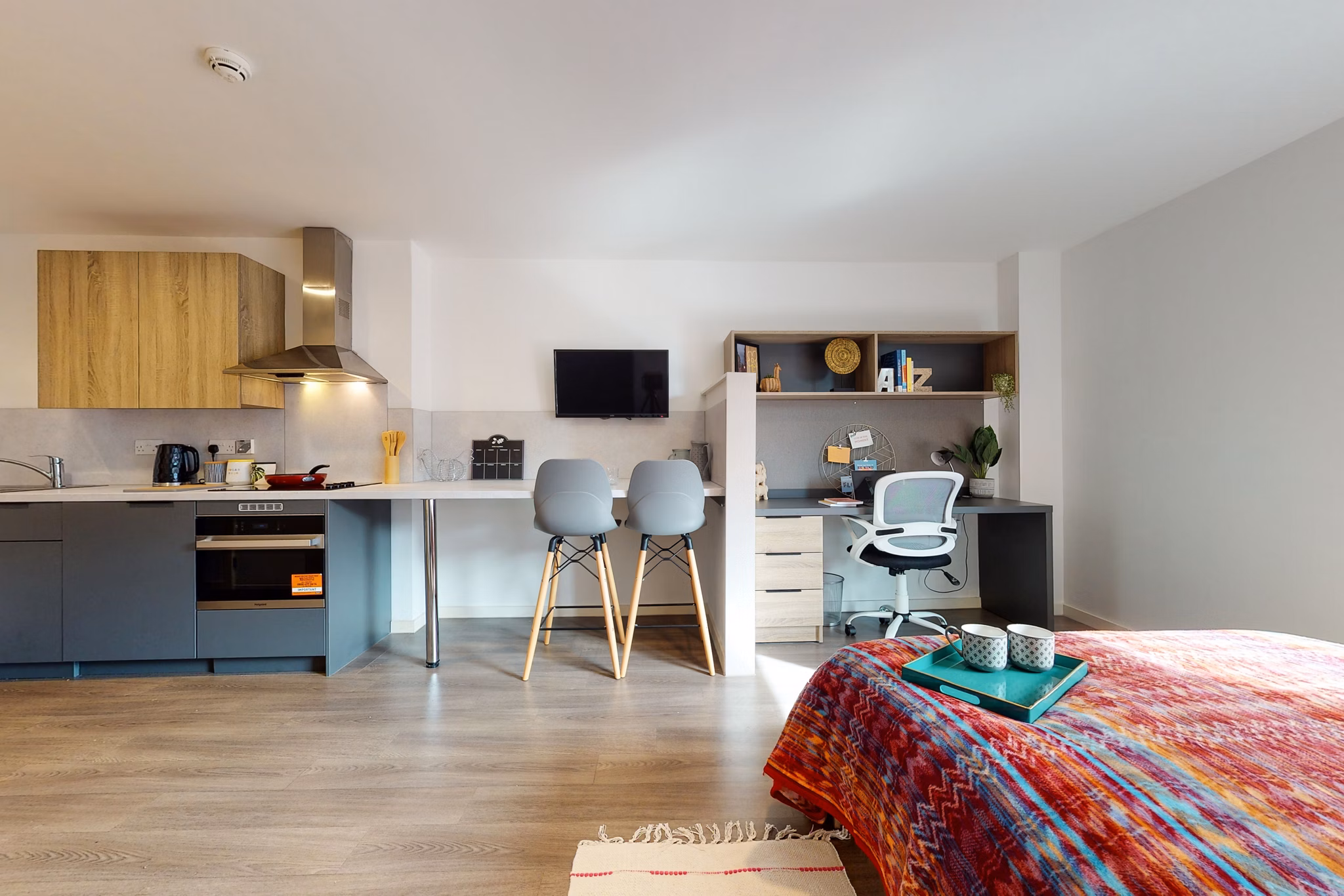 Modern interior at Canvas Glasgow featuring a combined living, dining, and kitchen area with vibrant decor.