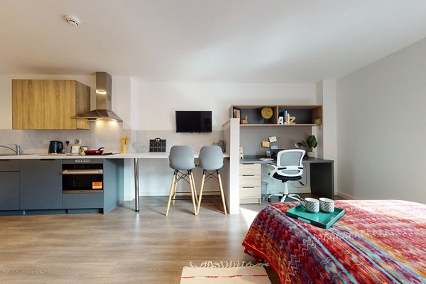 Modern interior at Canvas Glasgow featuring a combined living, dining, and kitchen area with vibrant decor.