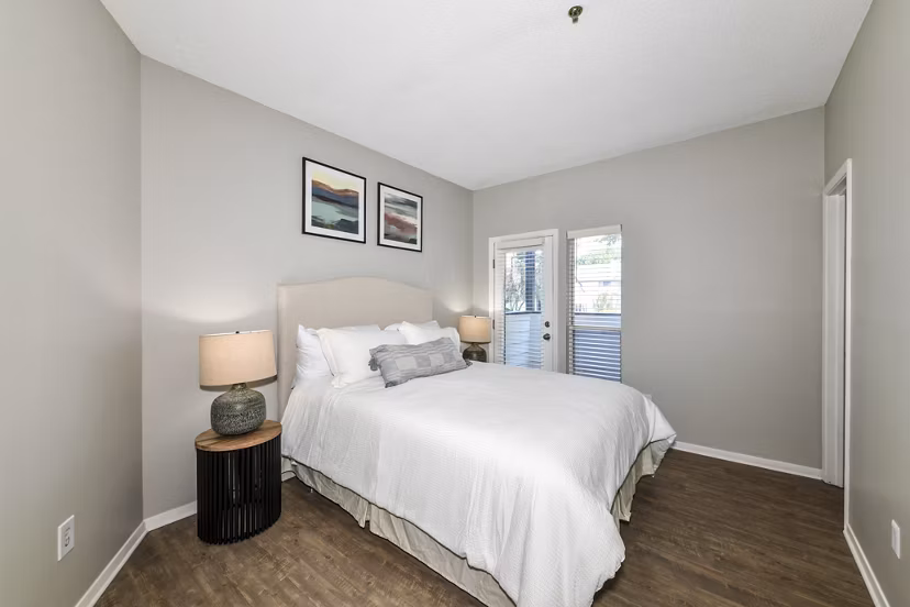 Cozy bedroom with large windows at Avana Dunwoody Apartments featuring modern design elements