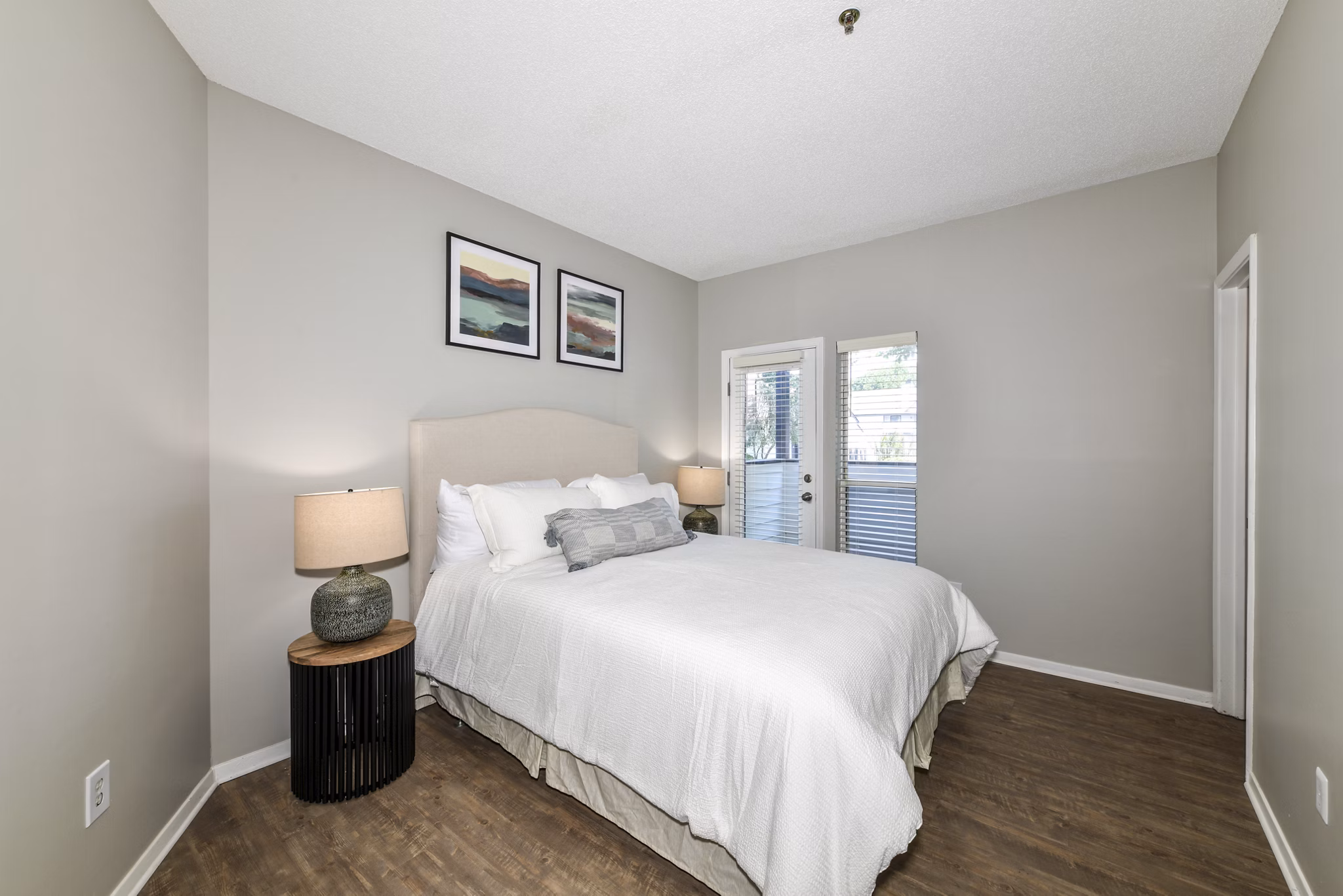Cozy bedroom with large windows at Avana Dunwoody Apartments featuring modern design elements