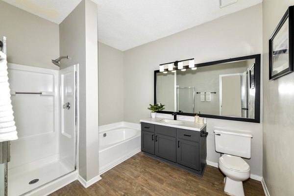 Modern bathroom with marble countertops and glass shower at Avana Dunwoody Apartments