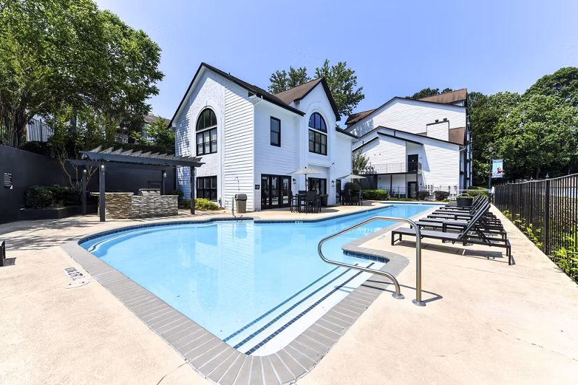 Luxurious pool at Avana Dunwoody Apartments featuring modern lounge chairs and lush landscaping
