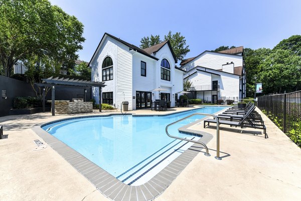 Luxurious pool at Avana Dunwoody Apartments featuring modern lounge chairs and lush landscaping
