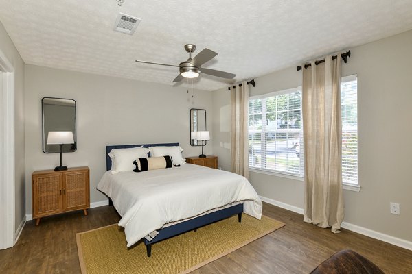 Cozy bedroom featuring modern decor and large windows at Avana Twenty9 Apartments