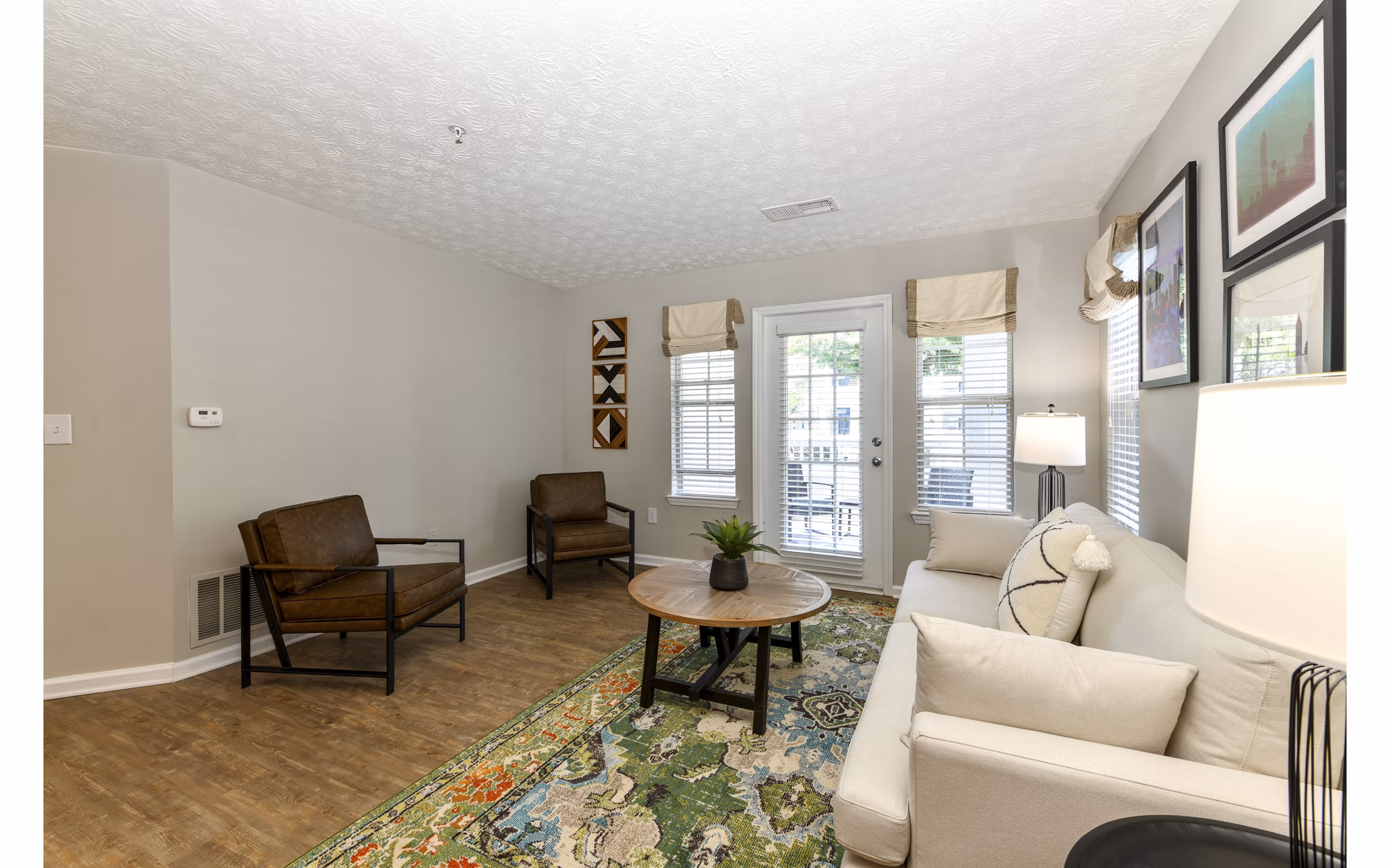 Modern living room with sleek furnishings and large windows in Avana Twenty9 Apartments