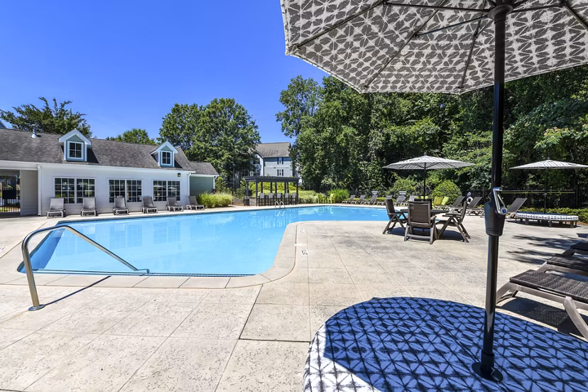 Outdoor pool with lounge chairs and landscaped surroundings at Avana Twenty9 Apartments