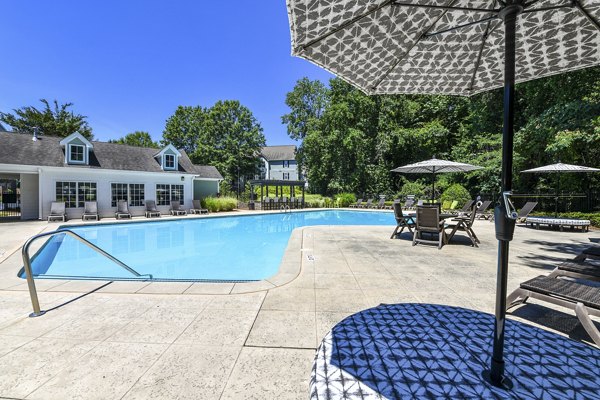 Outdoor pool with lounge chairs and landscaped surroundings at Avana Twenty9 Apartments