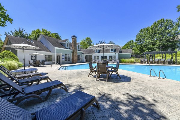 Sparkling outdoor pool at Avana Twenty9 Apartments with lounge chairs and umbrellas