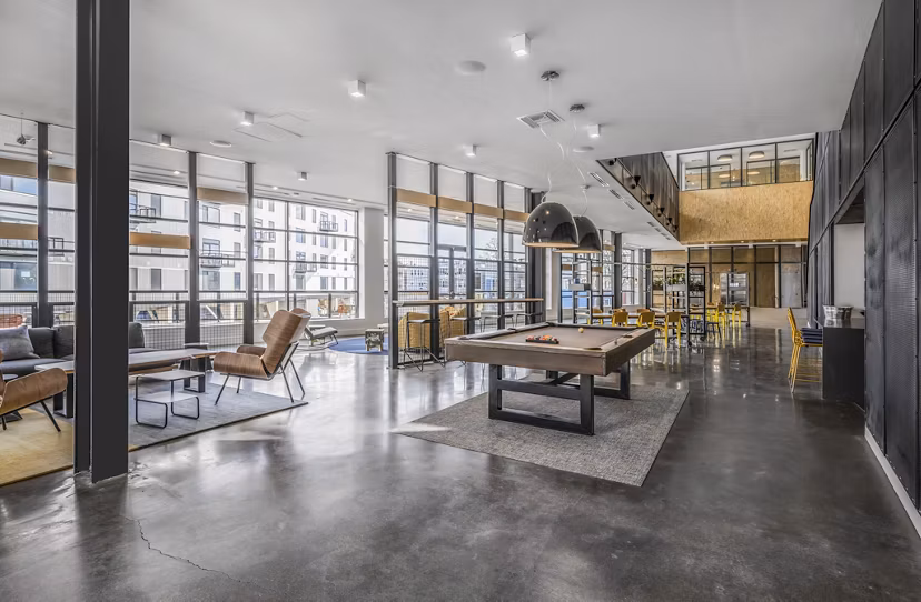 Modern clubhouse with lounge seating and large TV at Addison Apartments