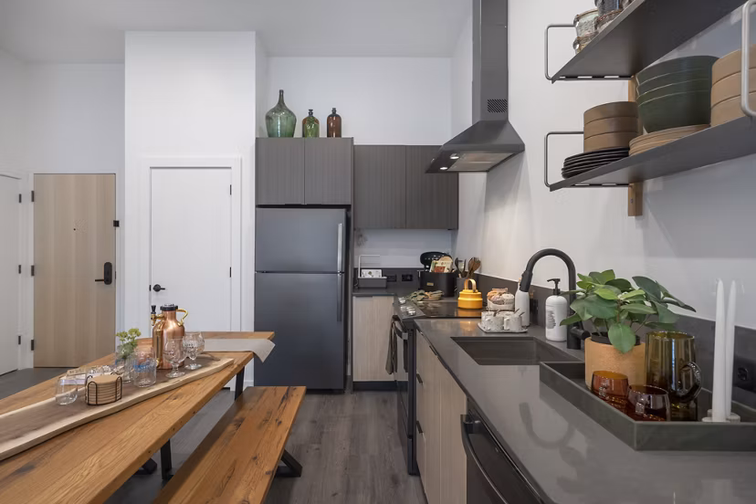 Modern kitchen featuring stainless steel appliances and marble countertops in Addison Apartments