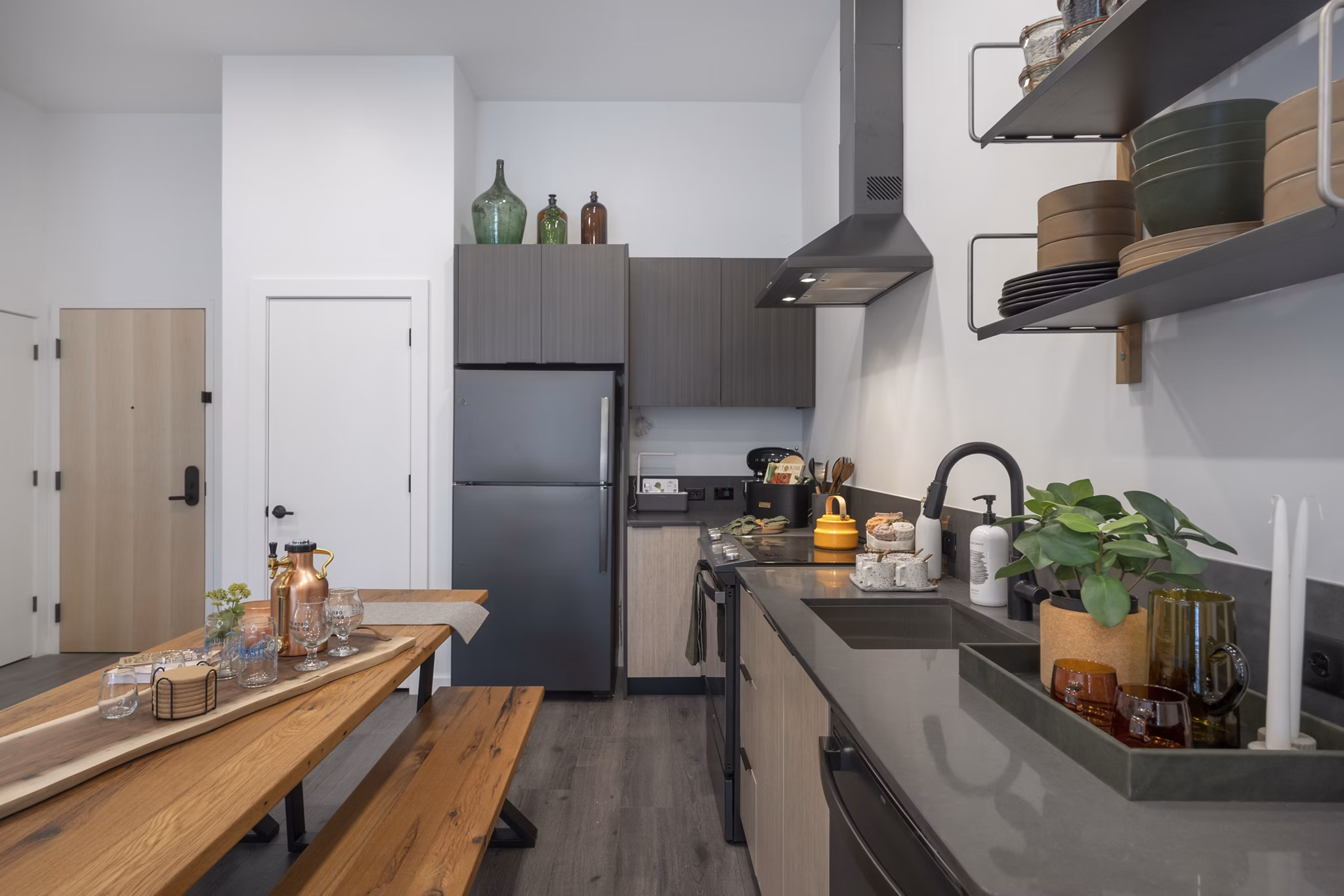 Modern kitchen featuring stainless steel appliances and marble countertops in Addison Apartments