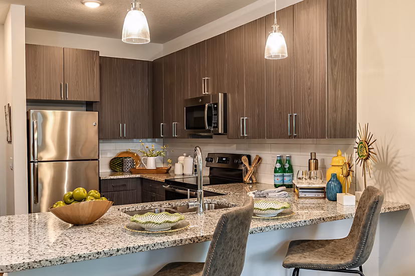 Modern kitchen featuring stainless steel appliances and quartz countertops at Kestra Apartments