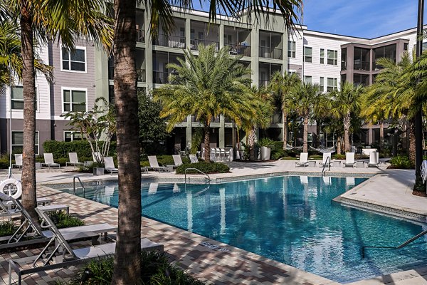 Luxurious pool area at Kestra Apartments with comfortable lounge seating and lush landscaping