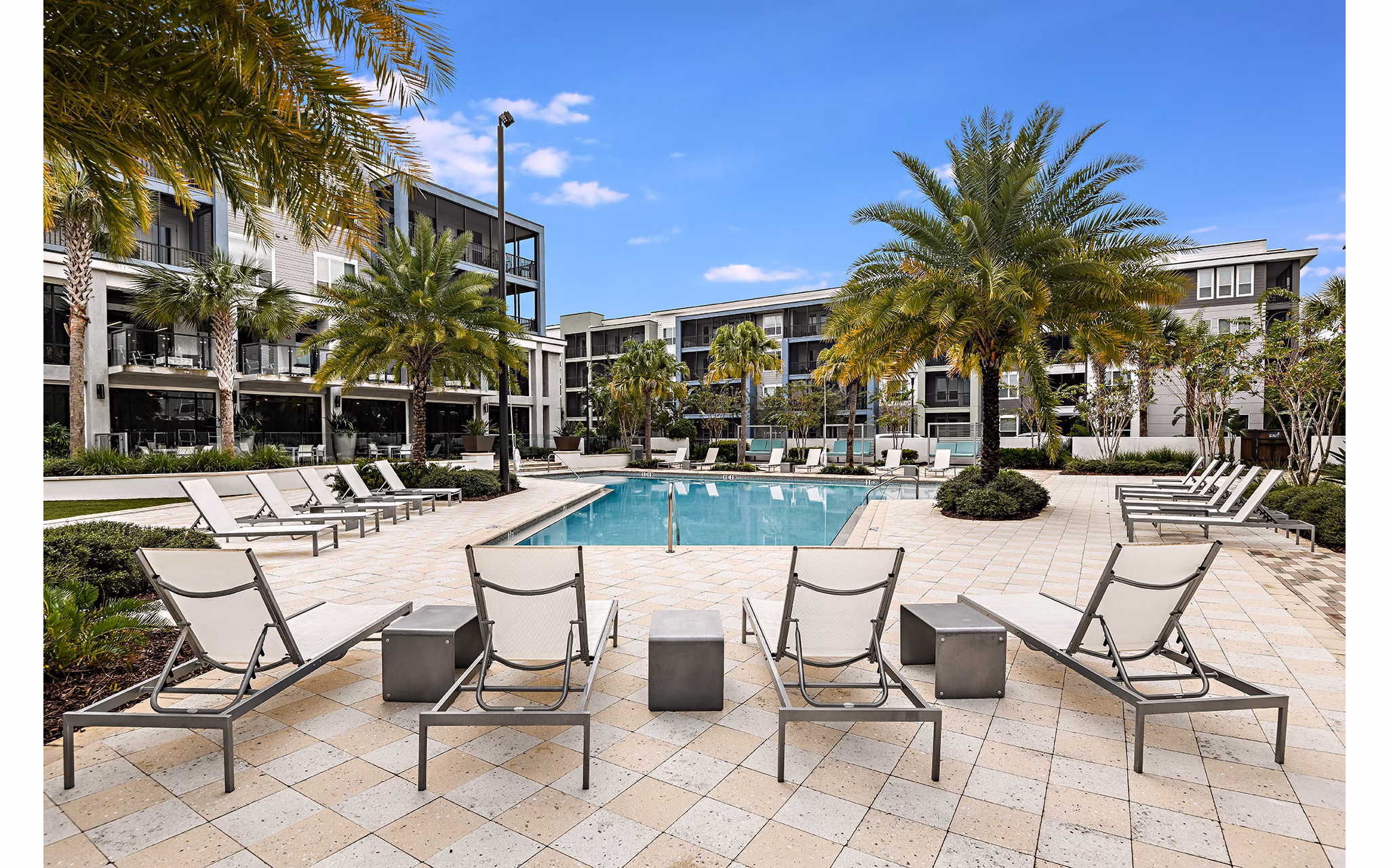 Luxury outdoor pool area with loungers at Kestra Apartments, ideal for relaxation and gatherings in a modern setting