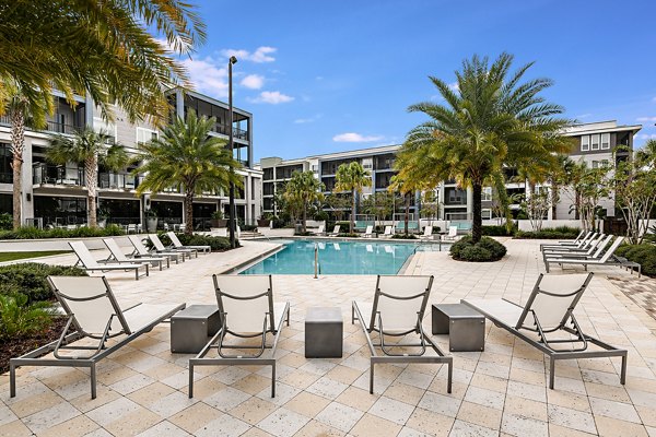 Luxury outdoor pool area with loungers at Kestra Apartments, ideal for relaxation and gatherings in a modern setting