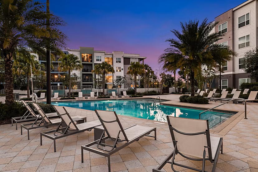 Luxury pool area at Kestra Apartments, featuring modern lounge chairs and lush landscaping, perfect for relaxation and recreation