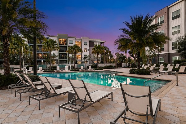 Luxury pool area at Kestra Apartments, featuring modern lounge chairs and lush landscaping, perfect for relaxation and recreation