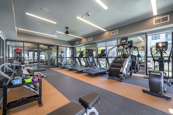 Fully-equipped fitness center at Coastline Ventura Apartments with modern workout machines and spacious exercise areas
