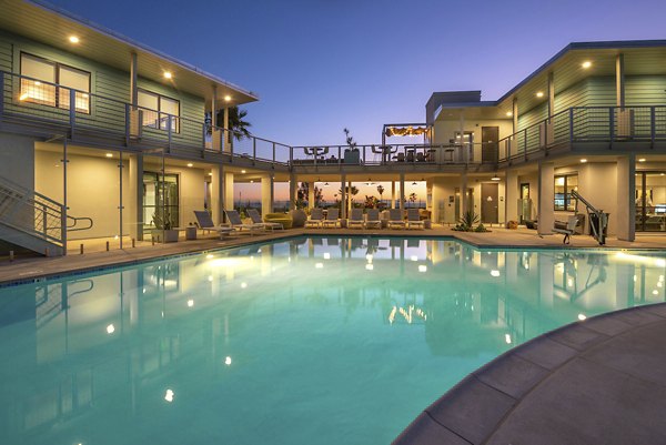 Elegant pool area with loungers at Coastline Ventura Apartments, offering luxury relaxation and leisure for residents