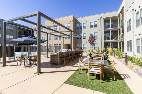 Chic outdoor patio area with seating and greenery at Overture Andalucia Apartments, perfect for relaxation and social gatherings