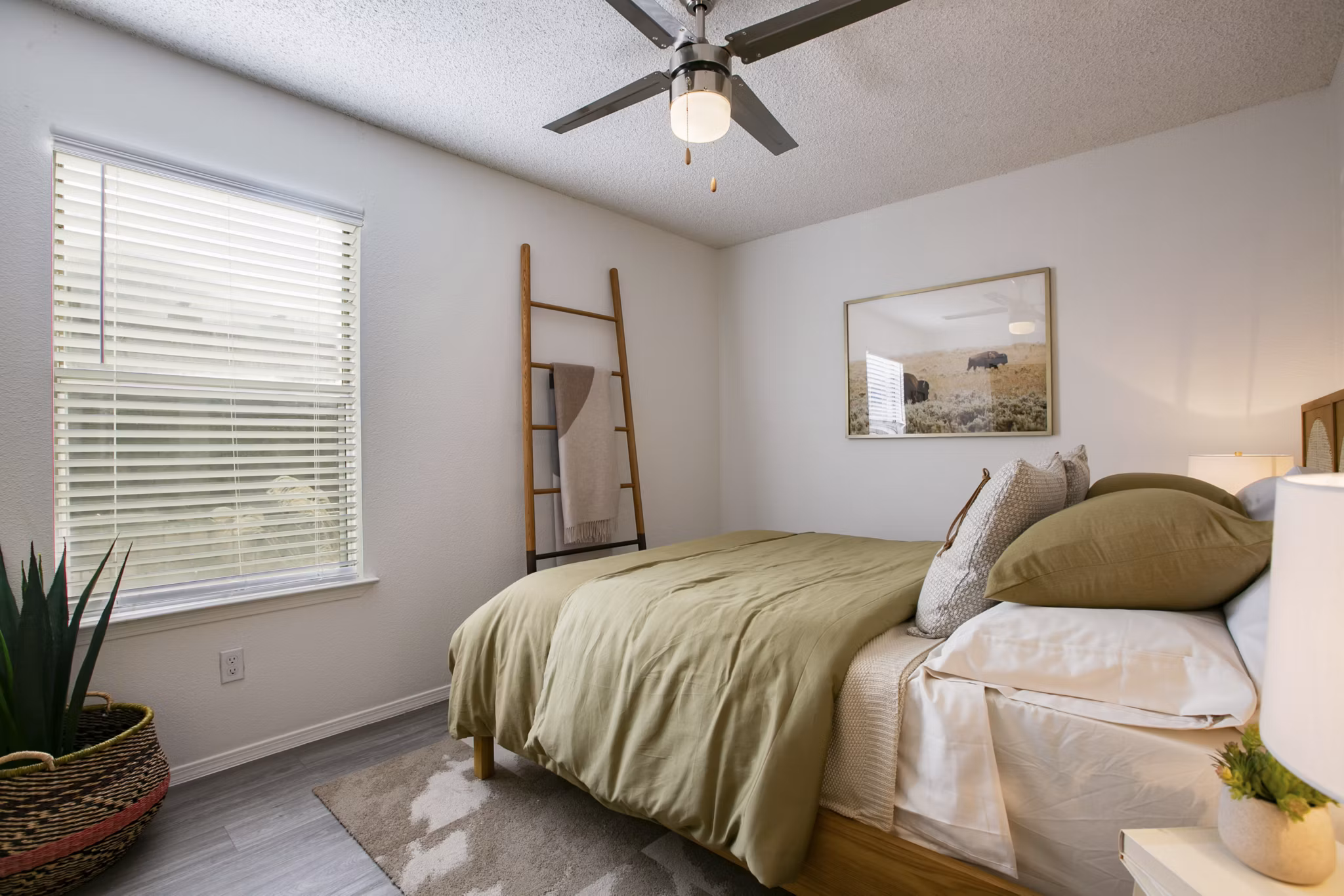 Bedroom with modern furnishings and large windows in Aydan Apartments