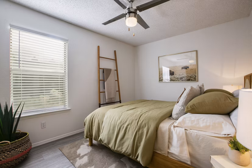 Bedroom with modern furnishings and large windows in Aydan Apartments