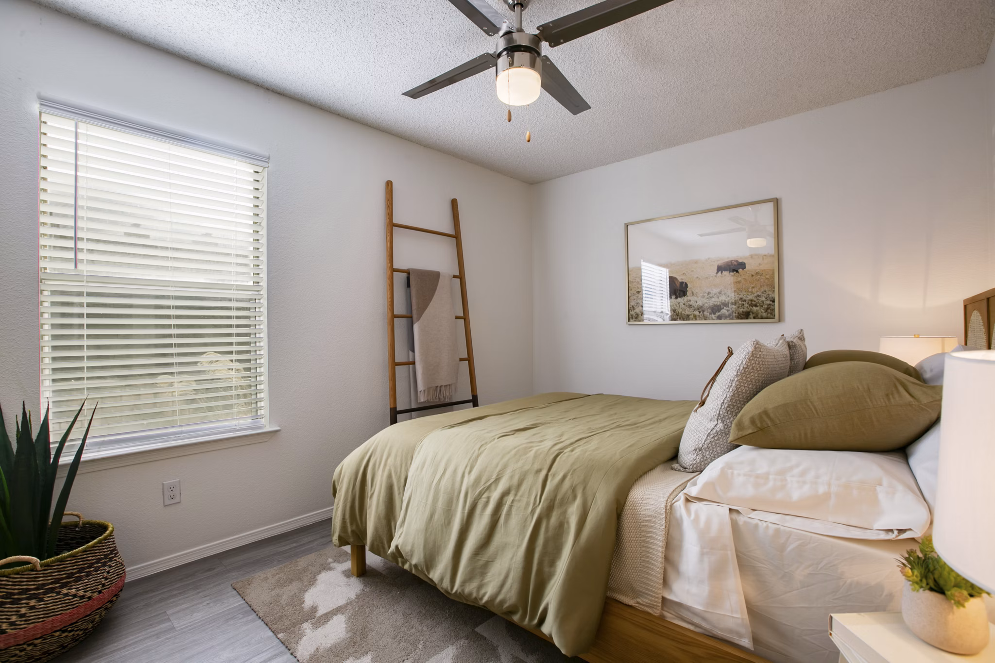 Bedroom with modern furnishings and large windows in Aydan Apartments
