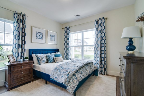 Bedroom featuring elegant decor and ample natural light in Vistas of Port Jefferson Apartments