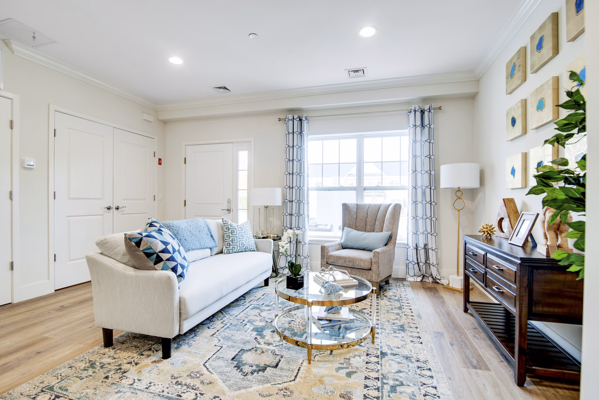 Living room with modern decor and large windows at Vistas of Port Jefferson Apartments