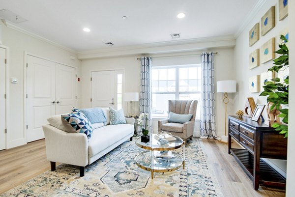Living room with modern decor and large windows at Vistas of Port Jefferson Apartments