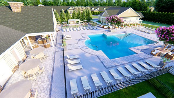 Resort-style pool with sun loungers at Vistas of Port Jefferson Apartments