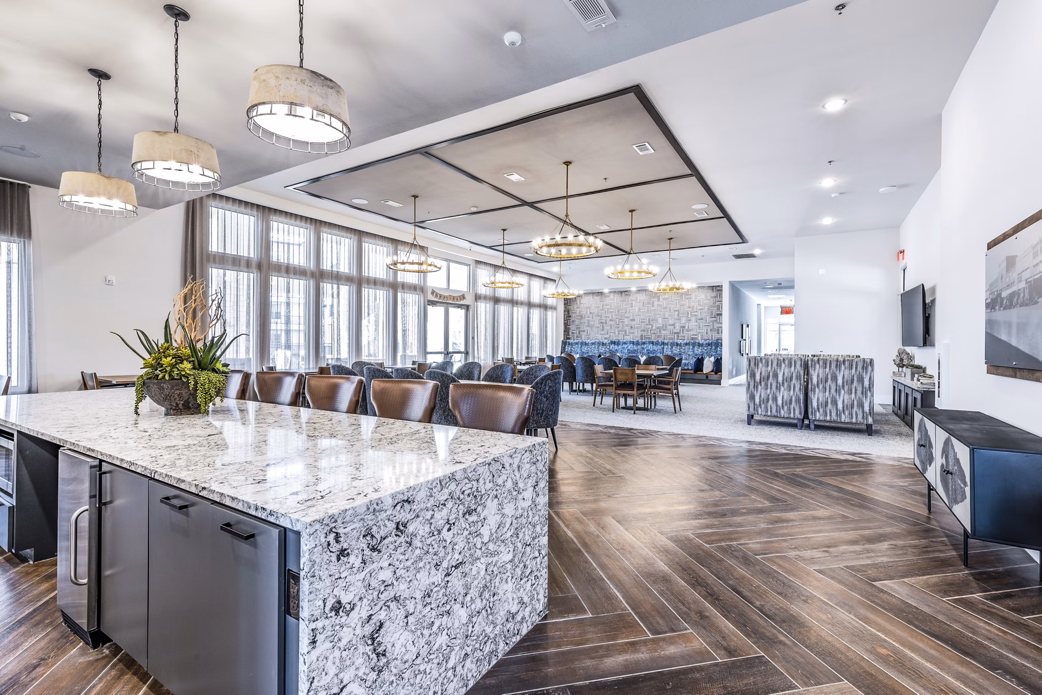 Elegant clubhouse dining room with modern decor at Album Mansfield Apartments, featuring communal tables and bright lighting for social gatherings