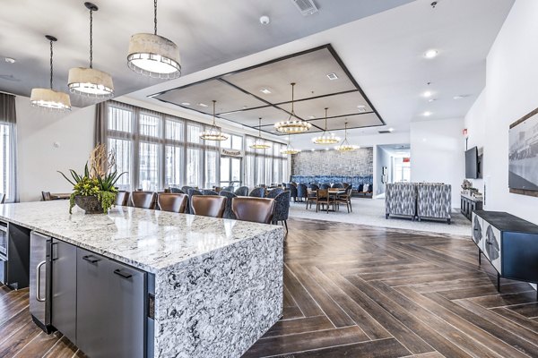 Elegant clubhouse dining room with modern decor at Album Mansfield Apartments, featuring communal tables and bright lighting for social gatherings