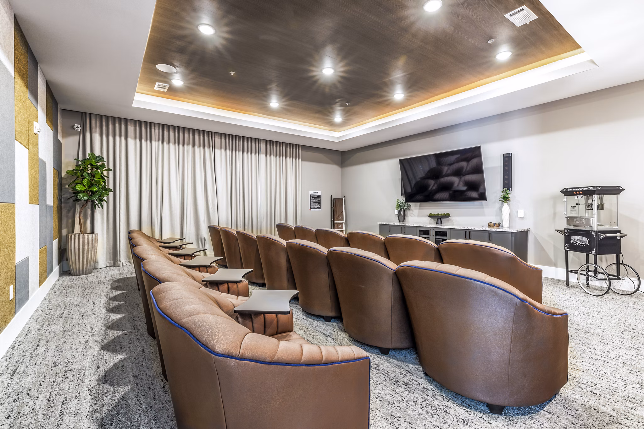 Clubhouse theater with plush seating and large screen at Album Mansfield Apartments