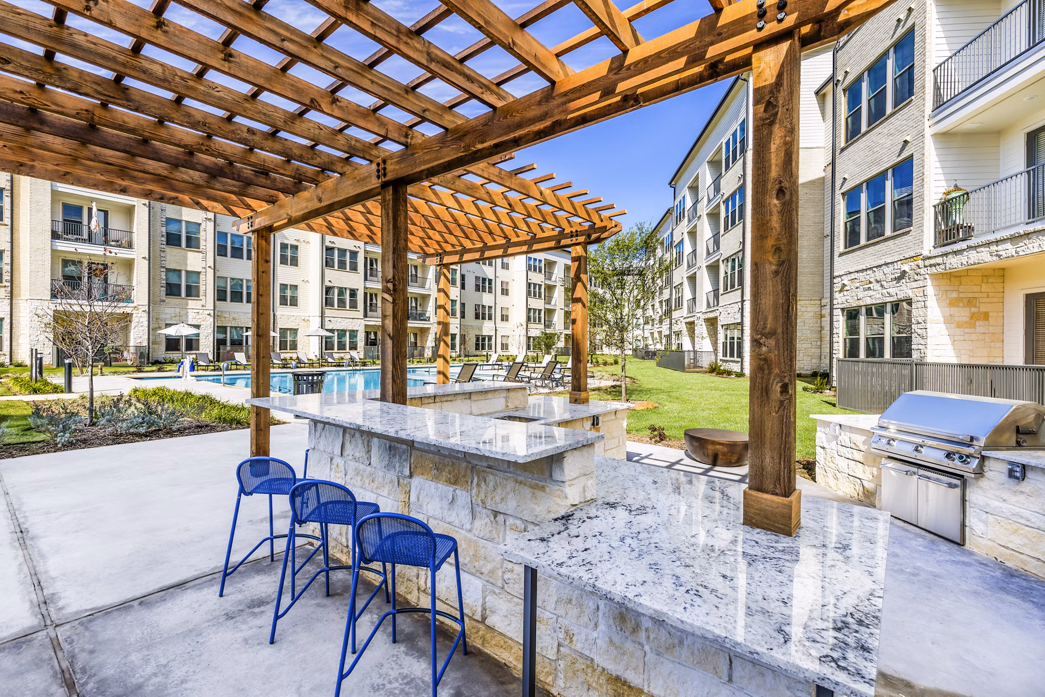 Outdoor grill area patio with modern seating at Album Mansfield Apartments, offering luxury community amenities for residents