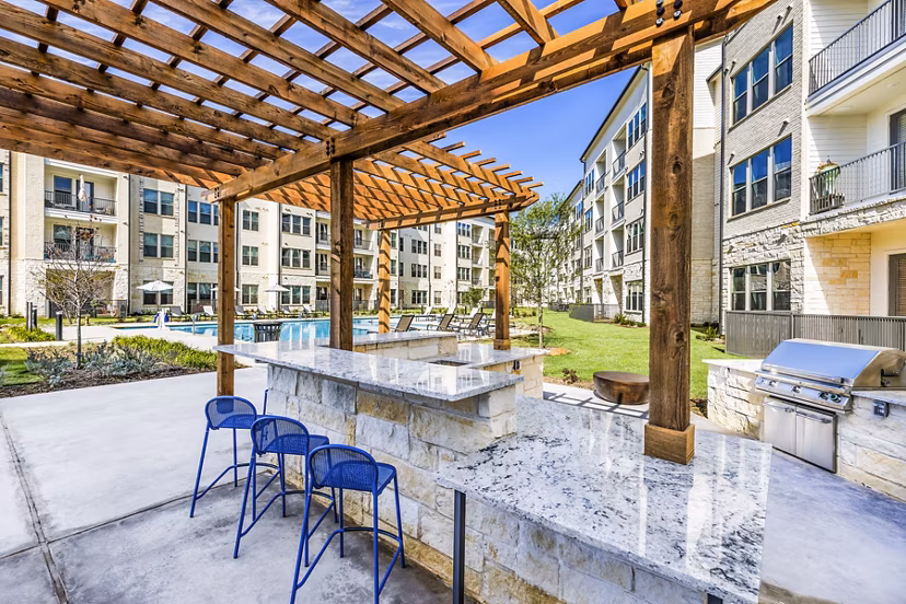 Outdoor grill area patio with modern seating at Album Mansfield Apartments, offering luxury community amenities for residents