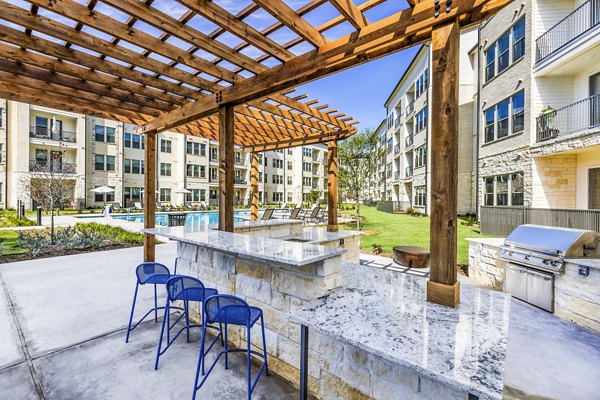 Outdoor grill area patio with modern seating at Album Mansfield Apartments, offering luxury community amenities for residents