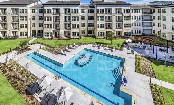 Relaxing poolside oasis at Album Mansfield Apartments, luxury living with water features and lounging areas in scenic surroundings